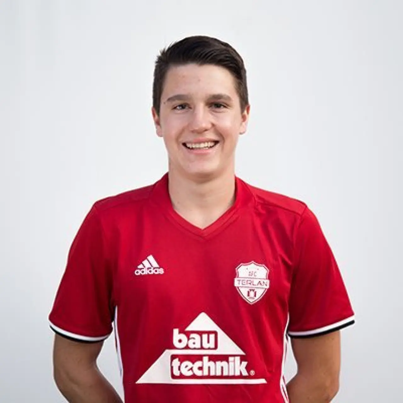 Porträtfoto von Lukas Palese im roten Trikot des AFC Terlan mit Bautechnik-Sponsorenlogo, vor weißem Hintergrund.