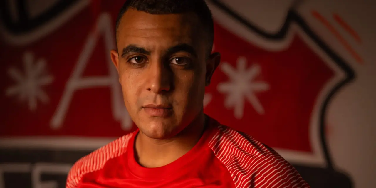 Porträt eines Spielers des AFC Terlan in roten Trikot mit Vereinswappen und Sponsor Bautechnik, vor einer roten Wand mit Vereinslogo.