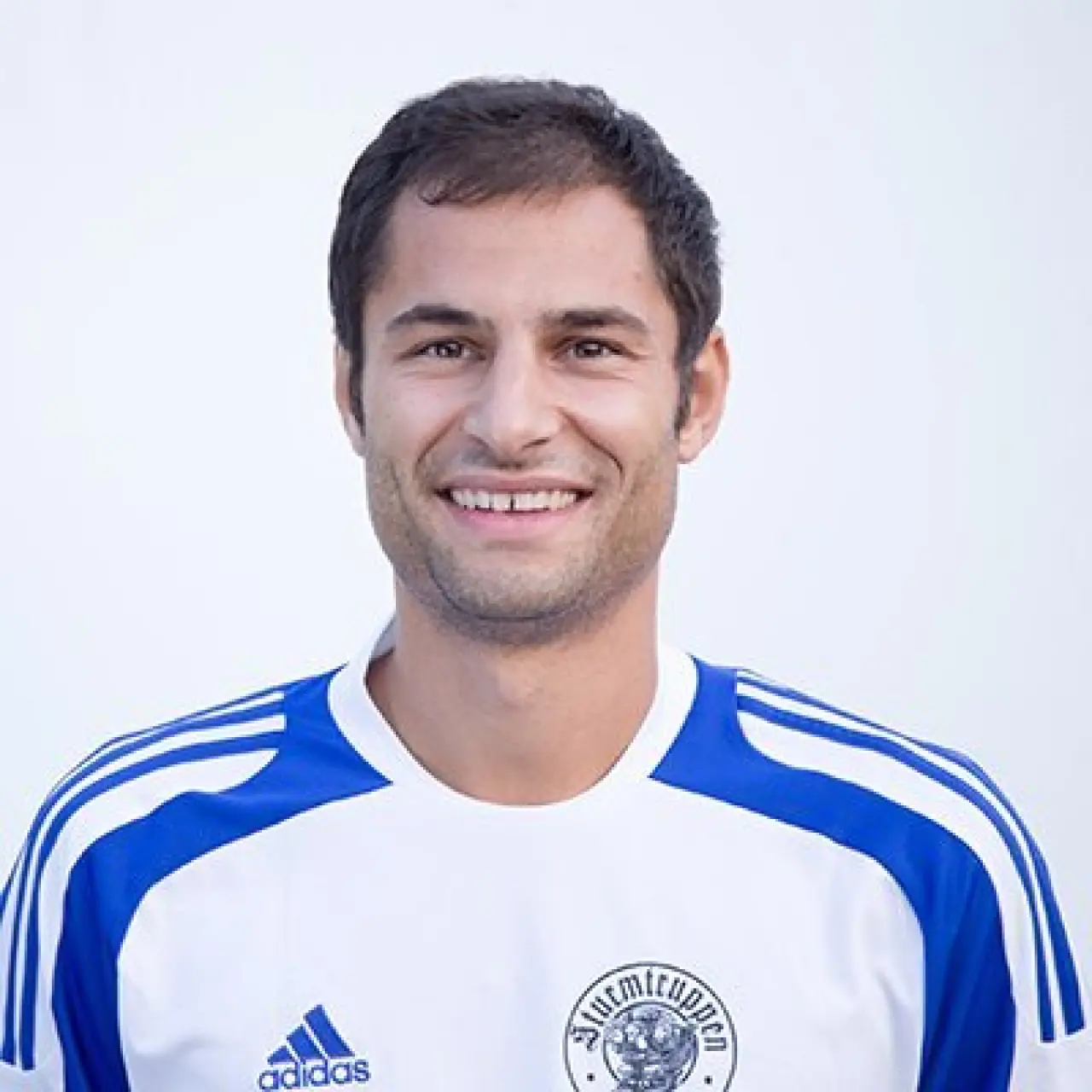 Porträt von Christoph Reiterer im weiß-blauen Trikot des AFC Terlan, lächelnd vor hellem Hintergrund.