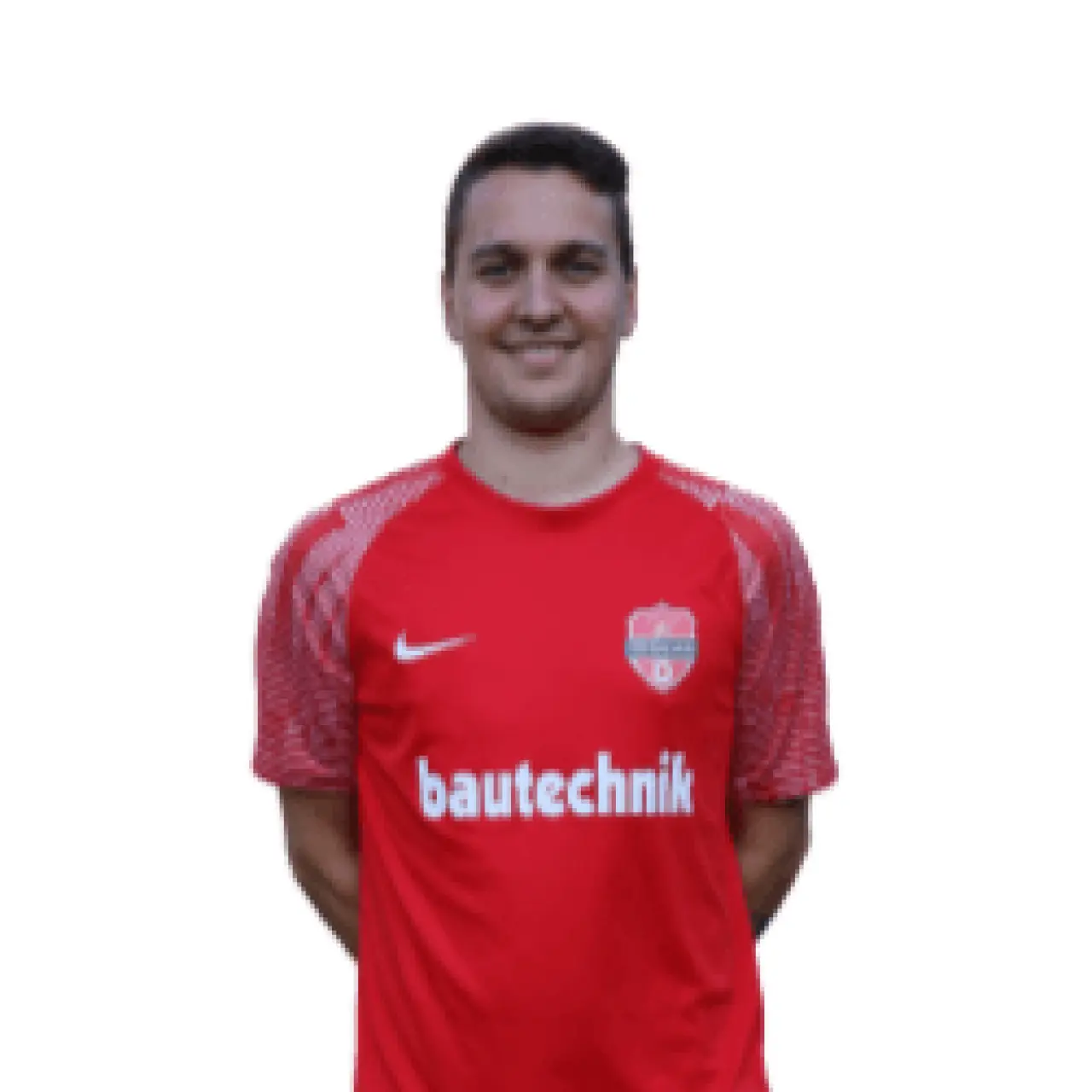 Porträtfoto eines lächelnden Mannes in roter Trikot mit Vereinswappen und Sponsor bautechnik vor weißem Hintergrund.