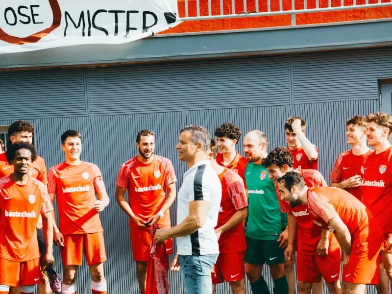 AFC-Terlan-Spieler in orangen Trikots verabschieden ihren Trainer mit dem Banner „Grazie x bellissimi 8 anni mister“.